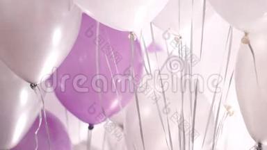 房间里漂浮着许多白色、粉红色和银氦气球